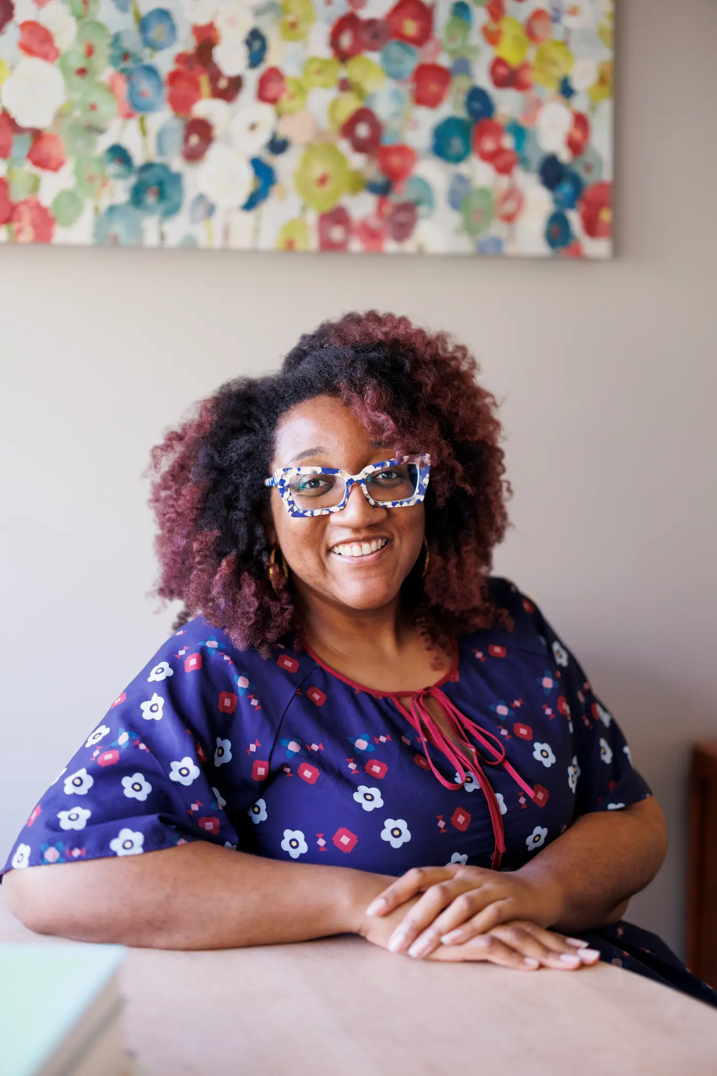 Shakira K O'Garro, LMHC-D, LPCC, LPC, NCC, smiling at her desk